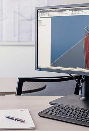 Vor Bildschirmen sitzender NeSt Konstrukteur arbeitet mit spezieller Software